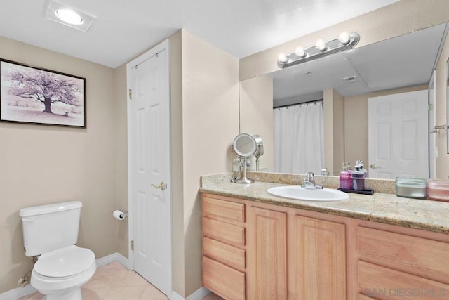 bathroom with tile patterned flooring, vanity, and toilet