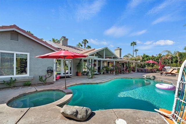 view of swimming pool featuring an in ground hot tub and a patio