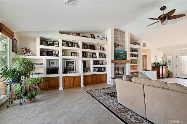 living room featuring built in shelves, a large fireplace, lofted ceiling, and light tile patterned floors