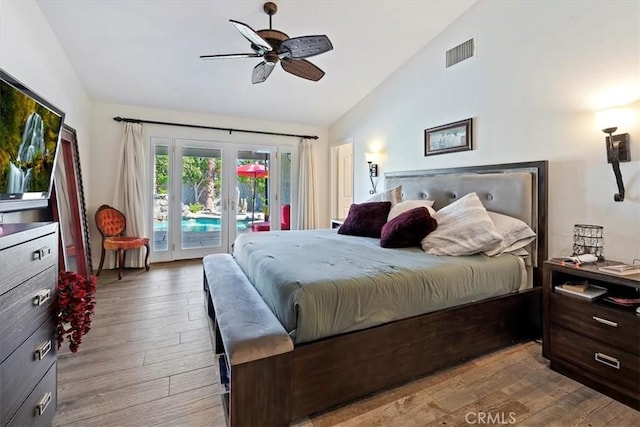 bedroom featuring vaulted ceiling, access to outside, light wood-type flooring, and french doors