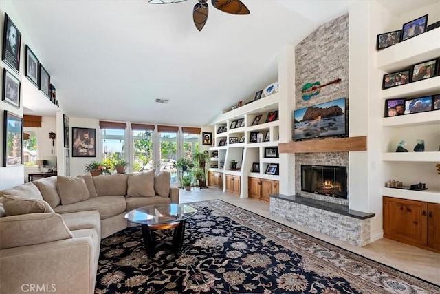 tiled living room featuring built in shelves, ceiling fan, lofted ceiling, and a fireplace