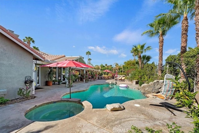 view of swimming pool featuring an in ground hot tub and a patio