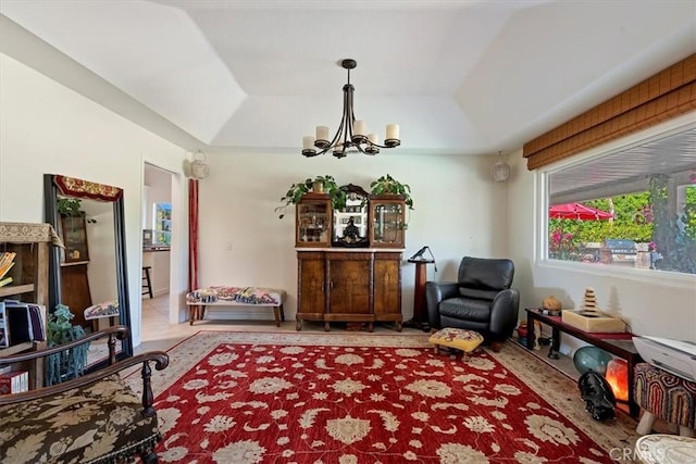 sitting room with a raised ceiling and an inviting chandelier