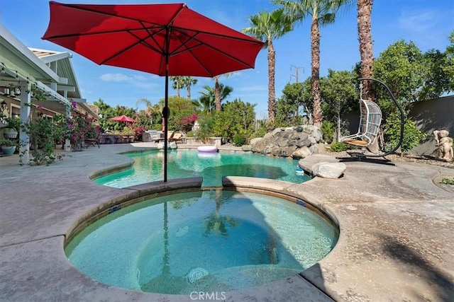 view of pool with an in ground hot tub and a patio area