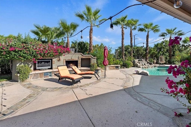 view of patio featuring an outdoor stone fireplace