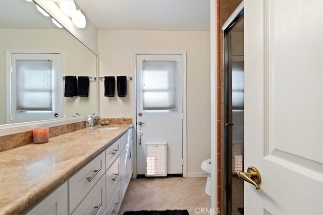 bathroom with tile patterned flooring, vanity, walk in shower, and toilet