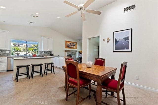 tiled dining space with lofted ceiling and ceiling fan