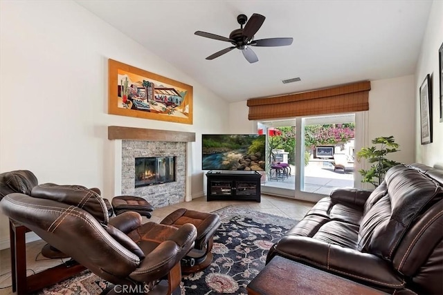 living room featuring light tile patterned flooring, lofted ceiling, ceiling fan, and a fireplace