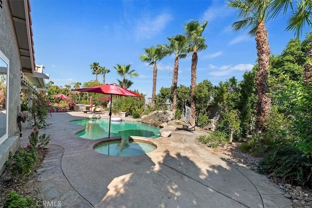 view of pool with a patio area and an in ground hot tub