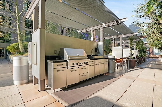 view of patio with exterior kitchen, area for grilling, sink, and a pergola