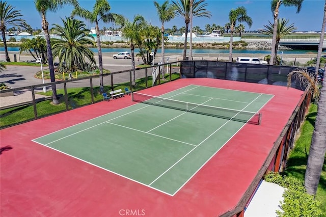 view of tennis court featuring a water view