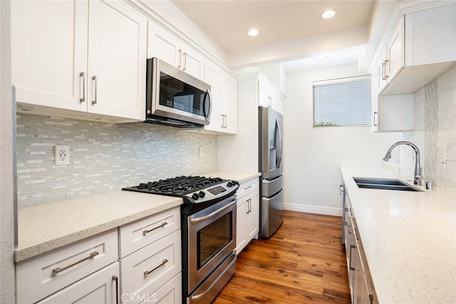 kitchen featuring white cabinetry, sink, light stone counters, and stainless steel appliances