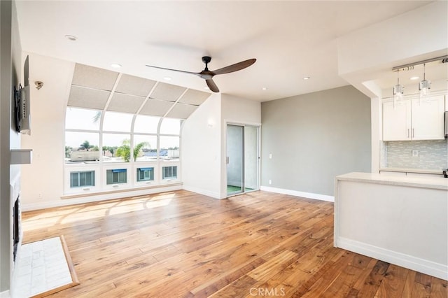 unfurnished living room featuring ceiling fan and light wood-type flooring