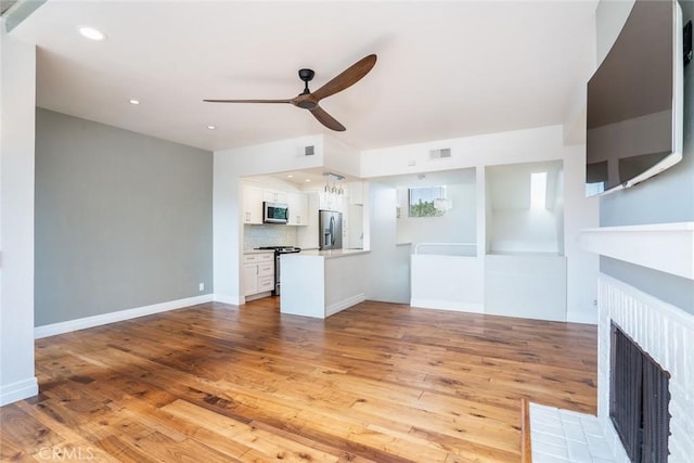 unfurnished living room with ceiling fan and light hardwood / wood-style floors