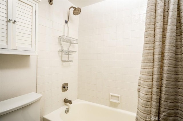 bathroom featuring shower / tub combo and toilet