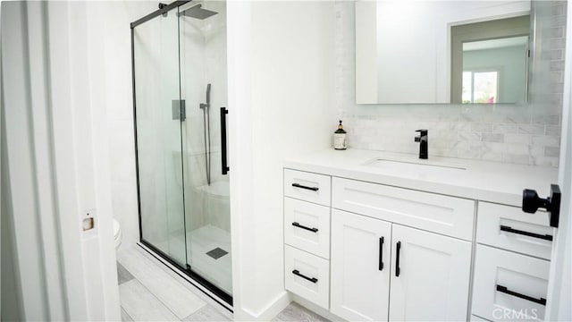 bathroom featuring walk in shower, vanity, toilet, and backsplash