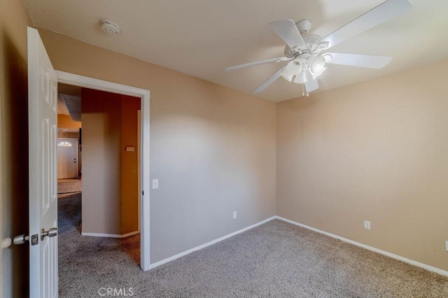 carpeted spare room featuring ceiling fan