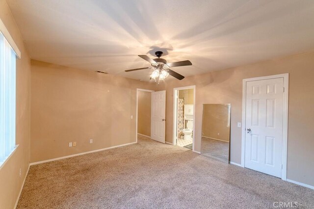 unfurnished bedroom featuring connected bathroom, light colored carpet, and ceiling fan