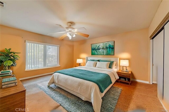 bedroom with ceiling fan, carpet floors, and a closet