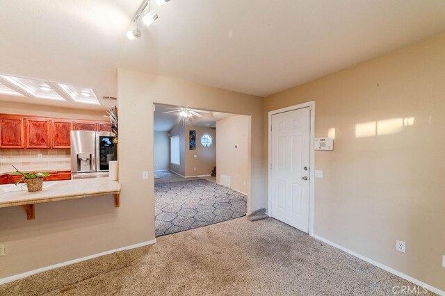 interior space featuring ceiling fan and light carpet