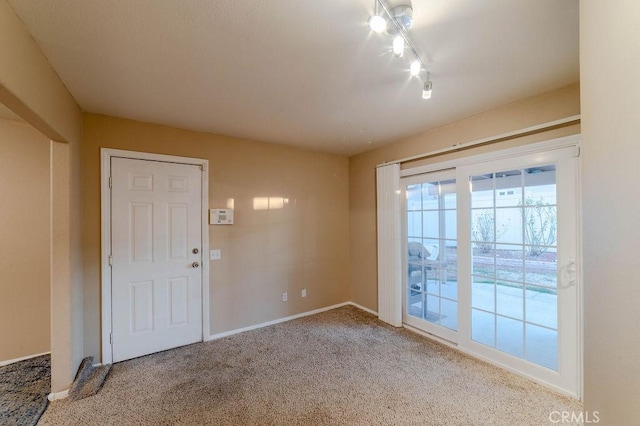 interior space with track lighting and carpet