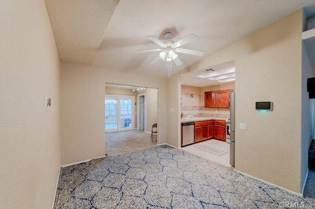 kitchen featuring light carpet, decorative backsplash, stainless steel dishwasher, and ceiling fan