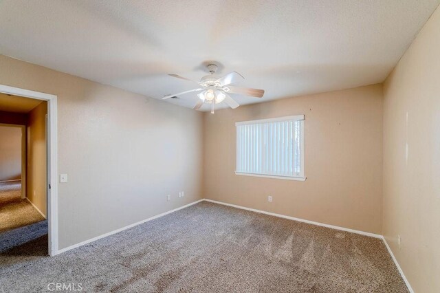 spare room featuring carpet and ceiling fan