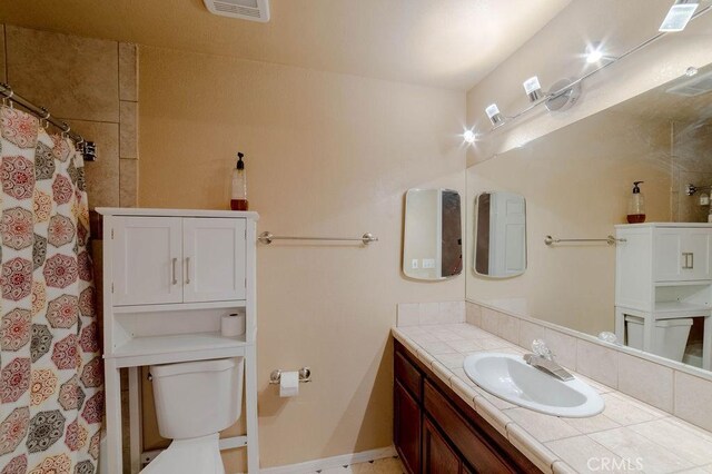 bathroom with walk in shower, vanity, and toilet