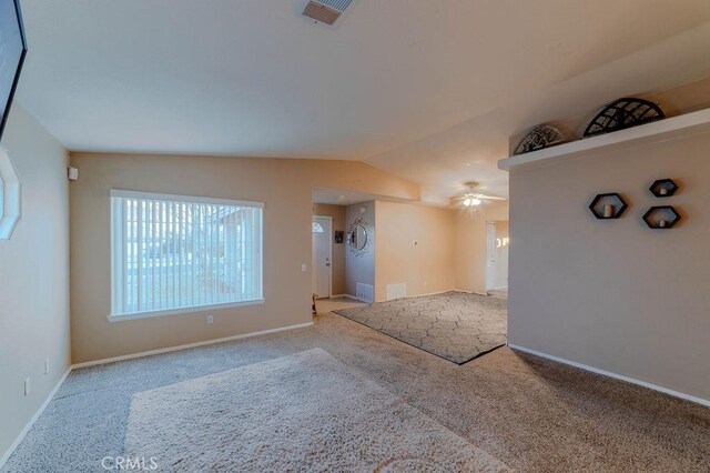 carpeted spare room featuring ceiling fan and lofted ceiling