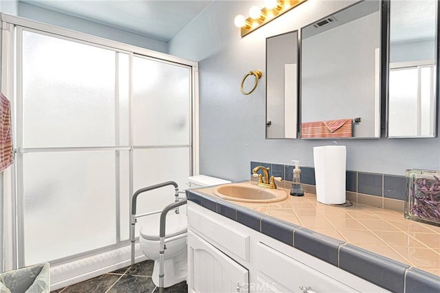 bathroom with vanity, toilet, and a shower with shower door