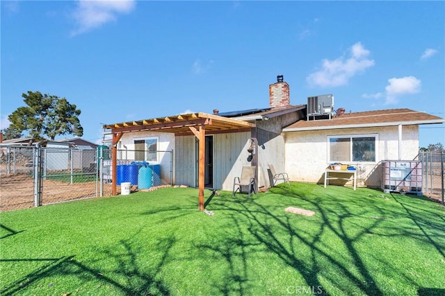 back of house with a yard, cooling unit, and solar panels