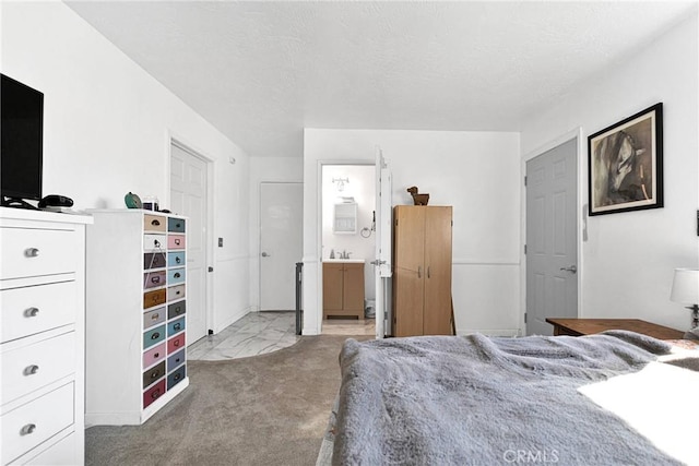 carpeted bedroom featuring sink and ensuite bathroom