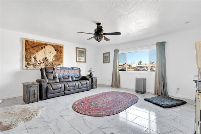 living room with ceiling fan and a textured ceiling