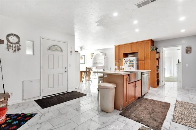 kitchen with sink, a center island with sink, a textured ceiling, stainless steel dishwasher, and ceiling fan