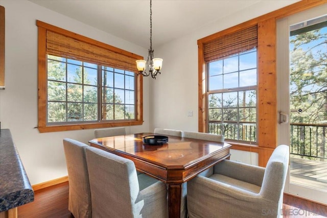 dining area with an inviting chandelier, dark hardwood / wood-style flooring, and a wealth of natural light