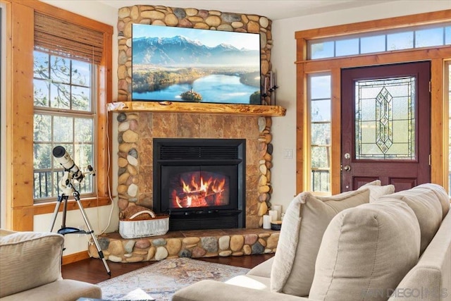 sitting room featuring a stone fireplace and hardwood / wood-style floors