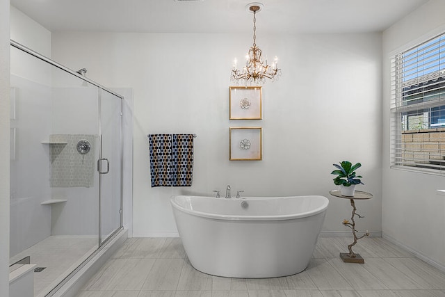 bathroom with a notable chandelier and shower with separate bathtub