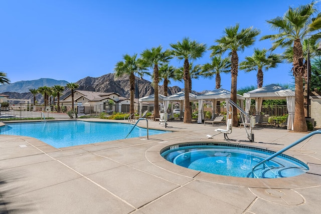 view of pool featuring a gazebo, a mountain view, a patio, and a community hot tub