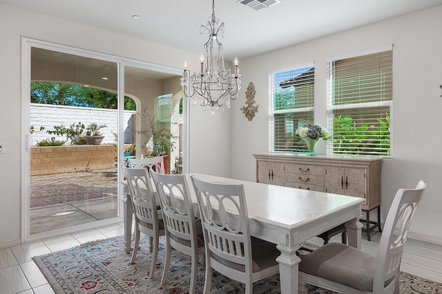 dining area with light tile patterned flooring and a notable chandelier