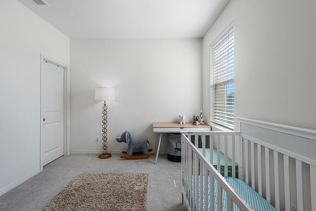 bedroom featuring a crib and light carpet