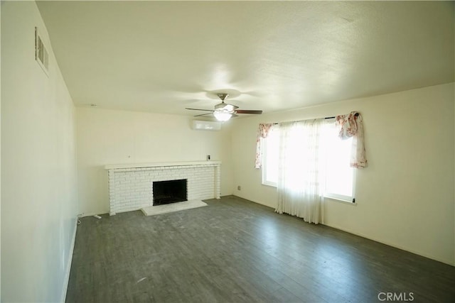 unfurnished living room with dark wood-type flooring, ceiling fan, and a brick fireplace