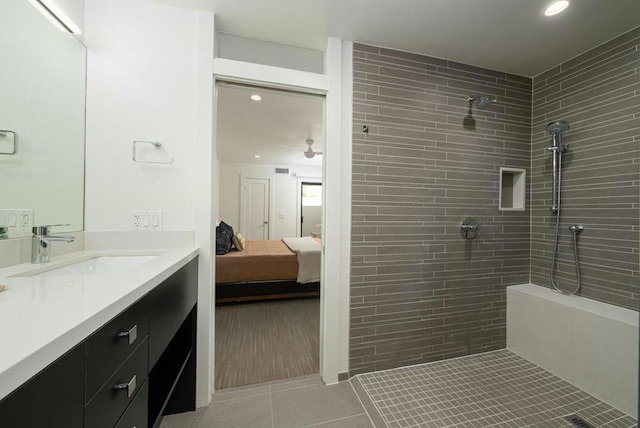 bathroom featuring vanity, tile patterned floors, and tiled shower