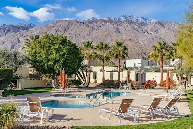 view of pool with a mountain view, a patio area, and a hot tub