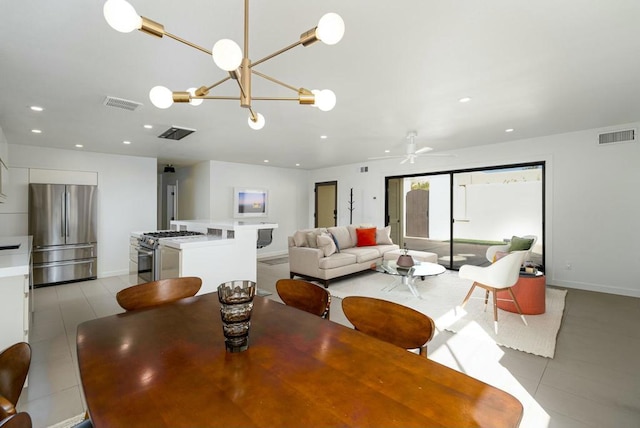 tiled dining space featuring ceiling fan with notable chandelier