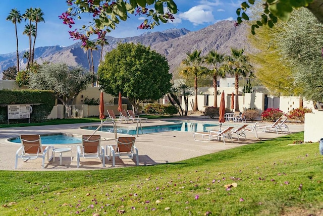 view of pool featuring a mountain view, a patio area, and a lawn