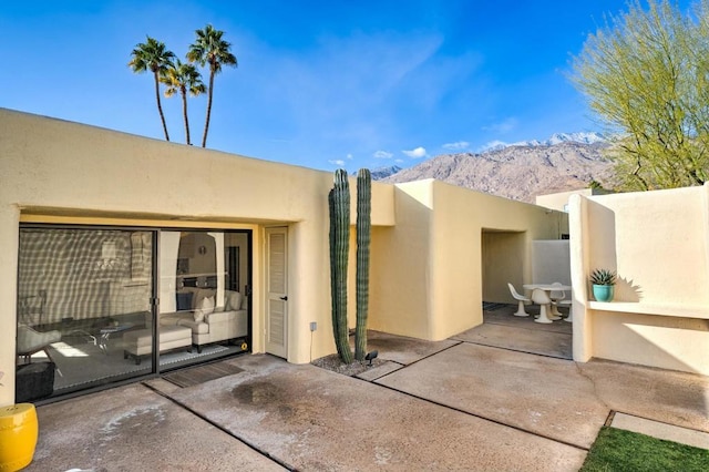 doorway to property with a mountain view and a patio