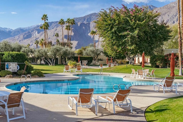 view of pool with a mountain view, a yard, and a patio area