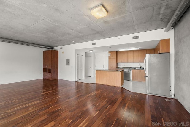 kitchen with sink, dark wood-type flooring, stainless steel appliances, and a kitchen island