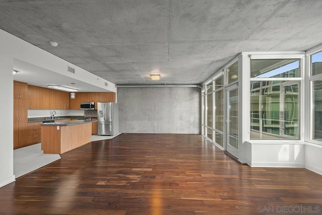 kitchen featuring appliances with stainless steel finishes, dark wood-type flooring, and a wealth of natural light