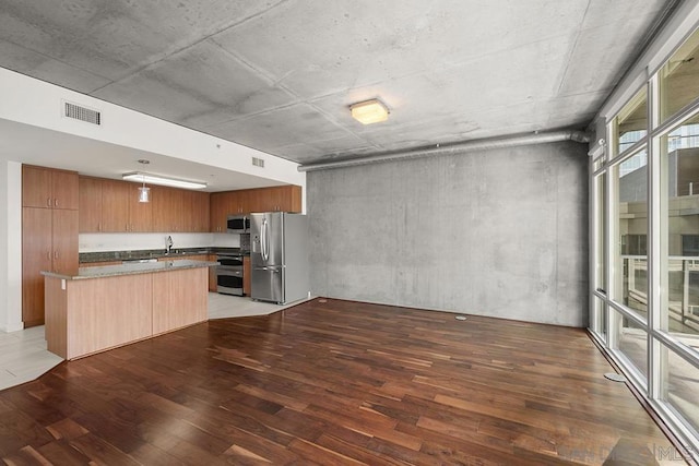 kitchen with light wood-type flooring, a center island, and appliances with stainless steel finishes